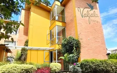 a yellow building with a sign on it at Hotel Valjala in Manizales