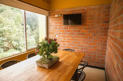 a wooden table with a potted plant on a brick wall at Hotel Valjala in Manizales