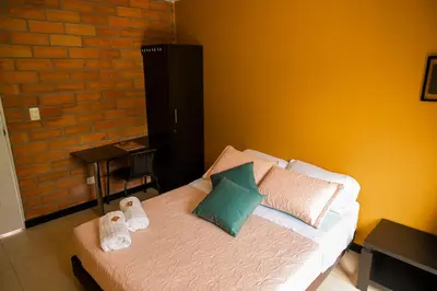 a bedroom with a bed with towels on it at Hotel Valjala in Manizales