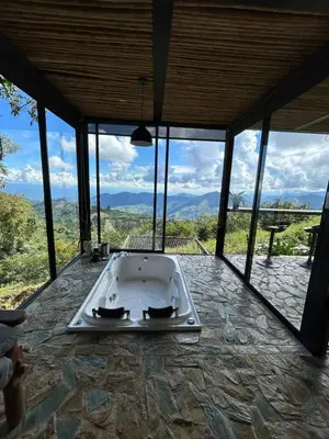 a large bath tub in a room with windows at GLAMPING ENTRE MONTES Y CAFETALES in Santuario