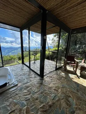 a room with a view of the mountains through glass at GLAMPING ENTRE MONTES Y CAFETALES in Santuario