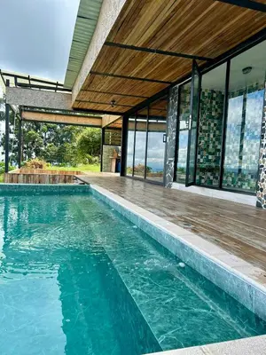 an empty swimming pool in a house with windows at GLAMPING ENTRE MONTES Y CAFETALES in Santuario