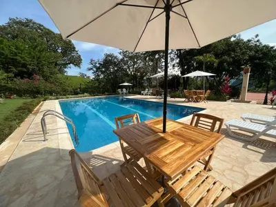 a wooden table with an umbrella next to a swimming pool at Hacienda San Francisco in Venecia