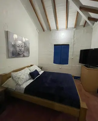 a bedroom with a bed and a flat screen tv at Hacienda San Francisco in Venecia