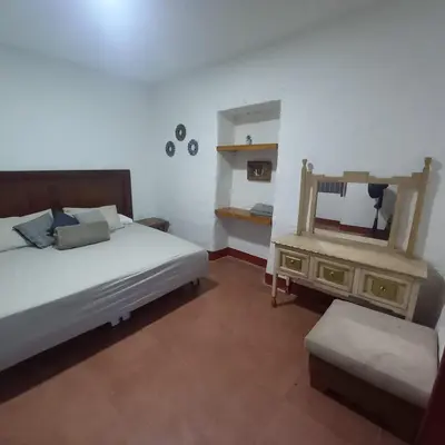 a bedroom with a bed and a dresser with a mirror at Hacienda San Francisco in Venecia