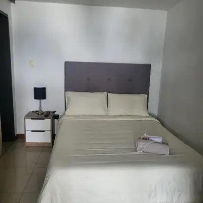 a bedroom with a large white bed with a headboard at LA CASA DEL CABLE -Atractivo Único Apartamento Sector Cable in Manizales