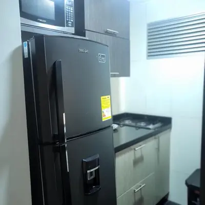 a black refrigerator in a kitchen with a microwave at LA CASA DEL CABLE -Atractivo Único Apartamento Sector Cable in Manizales