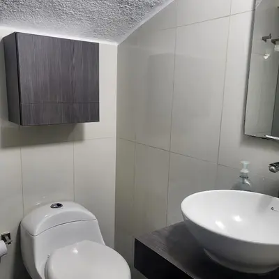 a white bathroom with a toilet and a sink at LA CASA DEL CABLE -Atractivo Único Apartamento Sector Cable in Manizales