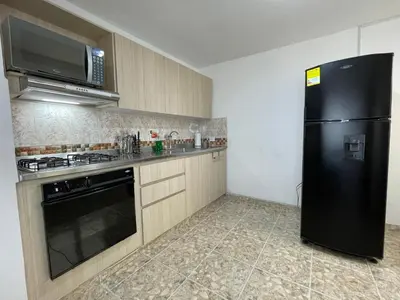 a kitchen with a black refrigerator and a microwave at Medellin Tu hogar en la eterna primavera in Medellín