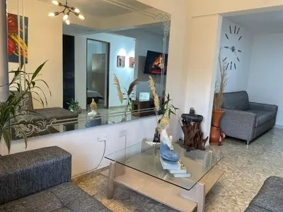 a living room with a table and a mirror at Medellin Tu hogar en la eterna primavera in Medellín
