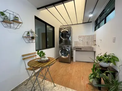 a laundry room with a washing machine and a table at Medellin Tu hogar en la eterna primavera in Medellín
