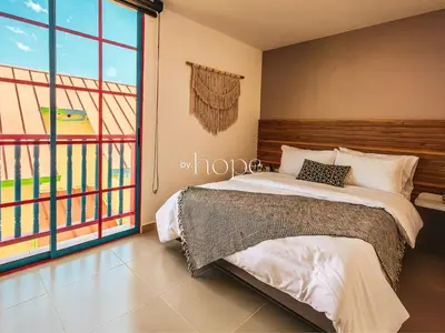 a bedroom with a bed and a large window at Aparta Hotel Guatape Faith 101 by Hope in Guatapé