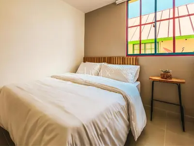 a bedroom with a bed and a window at Aparta Hotel Guatape Faith 101 by Hope in Guatapé