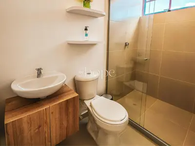 a bathroom with a toilet and a sink and a shower at Aparta Hotel Guatape Faith 101 by Hope in Guatapé