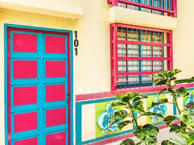 a pair of red doors and windows on a building at Aparta Hotel Guatape Faith 101 by Hope in Guatapé