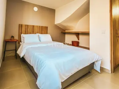 a bedroom with a large white bed in a room at Aparta Hotel Guatape Faith 101 by Hope in Guatapé