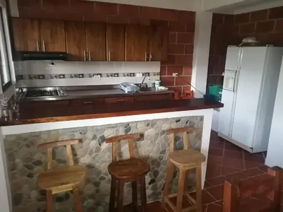 a kitchen with a counter and two stools in it at Casa Alejandria in Alejandría