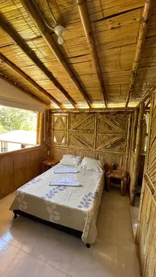 a bed in a room with a wooden ceiling at Hostería El Sendero - Cocorná in Cocorná