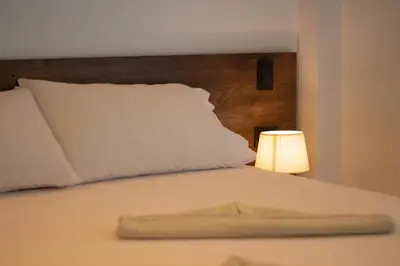 a white bed with a white pillow and a lamp at Hostería El Sendero - Cocorná in Cocorná