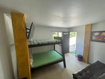 a room with two bunk beds and a couch at Hostería El Sendero - Cocorná in Cocorná