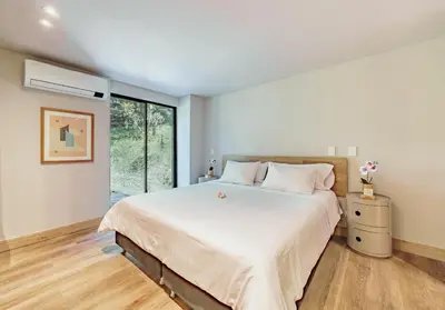 a bedroom with a large bed and a window at The Somos Central Hotel Poblado in Medellín