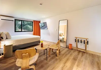 a hotel room with a bed and a mirror at The Somos Central Hotel Poblado in Medellín