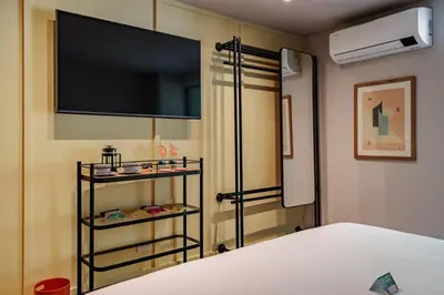 a bedroom with a bed with a flat screen tv at The Somos Central Hotel Poblado in Medellín