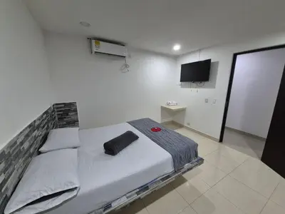 a bedroom with a bed with a tv on the wall at Hotel Spa Laureles in Medellín