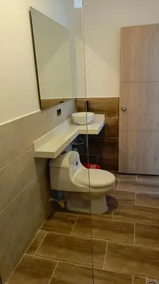 a bathroom with a toilet and a sink and a mirror at Hotel Spa Laureles in Medellín