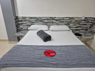 a bedroom with a bed with a pillow on it at Hotel Spa Laureles in Medellín