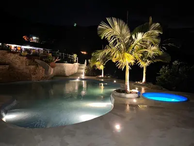 a swimming pool at night with a palm tree at Eco Hotel Samaria , Aguas y Bosques in San Rafael