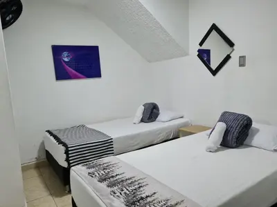 a room with two beds and a picture on the wall at NEW COZY APARTMENT 101 IN MEDELLIN, ENVIGADO in Envigado