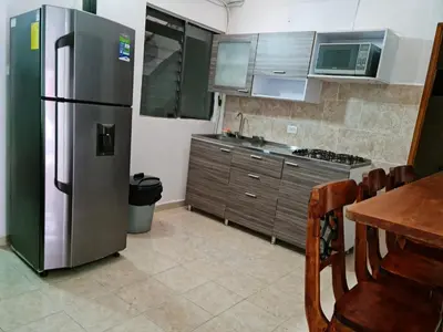 a kitchen with a stainless steel refrigerator and a table at NEW COZY APARTMENT 101 IN MEDELLIN, ENVIGADO in Envigado