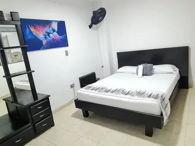 a bedroom with a bed and a black dresser at NEW COZY APARTMENT 101 IN MEDELLIN, ENVIGADO in Envigado