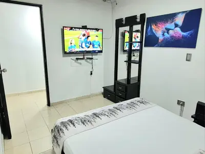 a room with a bed and a flat screen tv at NEW COZY APARTMENT 101 IN MEDELLIN, ENVIGADO in Envigado
