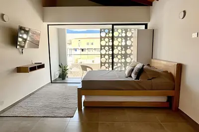 a bedroom with a bed and a door to a balcony at Tranvia 40 - Amoblados Velasquez in Medellín