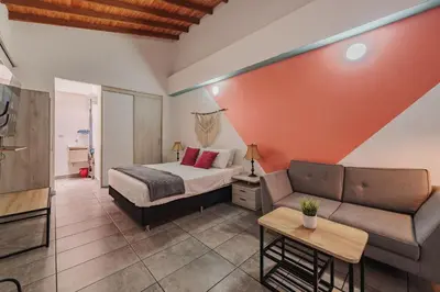 a bedroom with a bed and a couch at Tranvia 40 - Amoblados Velasquez in Medellín