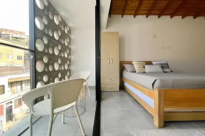 a bedroom with a bed and a chair and a window at Tranvia 40 - Amoblados Velasquez in Medellín