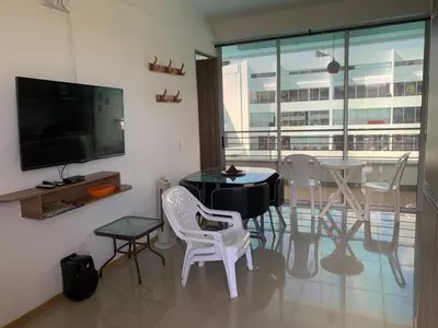 a living room with a table and chairs and a television at Disfruta en Paraíso del Sol T9-402 in San Jerónimo