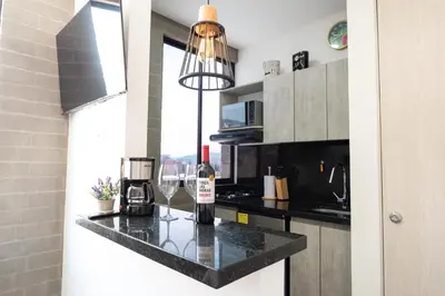 a kitchen with a bottle of wine on a counter at Cozy New Loft in Laureles / Estadio! in Medellín