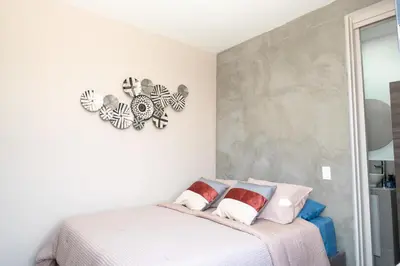 a bedroom with a bed and a clock on the wall at Cozy New Loft in Laureles / Estadio! in Medellín