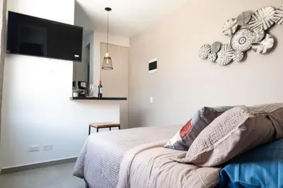 a bedroom with a bed and a flat screen tv at Cozy New Loft in Laureles / Estadio! in Medellín