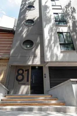 a building with a tower with a door and stairs at Cozy New Loft in Laureles / Estadio! in Medellín