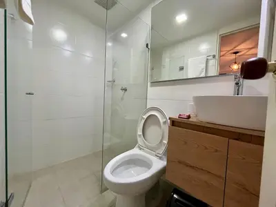 a bathroom with a toilet and a sink and a shower at Apartahotel Rosedal in Doradal