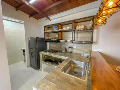 a kitchen with a sink and a refrigerator at Apartahotel Rosedal in Doradal