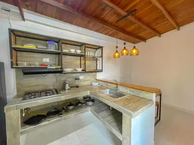 a kitchen with a sink and a stove at Apartahotel Rosedal in Doradal