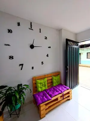 a room with a purple couch and a clock on the wall at OSIMiRI PLAZA Apartamento Naturaleza y aventura in San Rafael