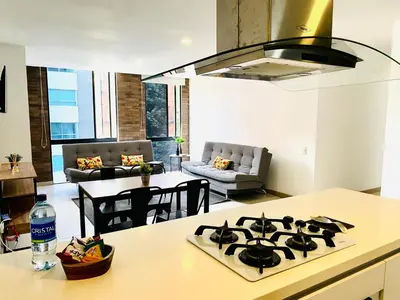 a kitchen with a stove top in a living room at Apartamento Lauret en Laureles in Medellín
