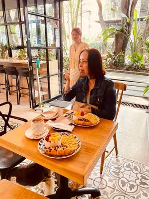 a woman sitting at a table with plates of food at Apartamento Lauret en Laureles in Medellín