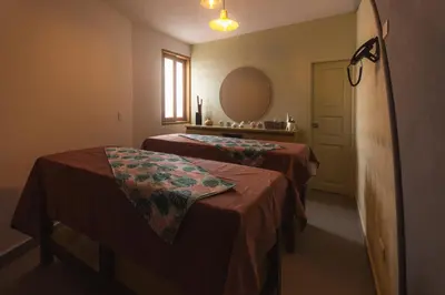 a room with two beds and a mirror at Hotel Chromatic in Guatapé